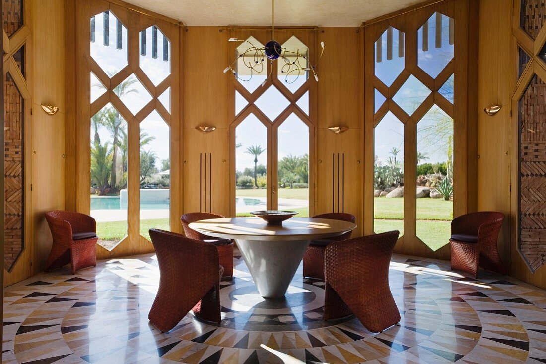 Marble and oak round table by Zervaco in octagonal dining room with marble flooring and italian woven leather chairs