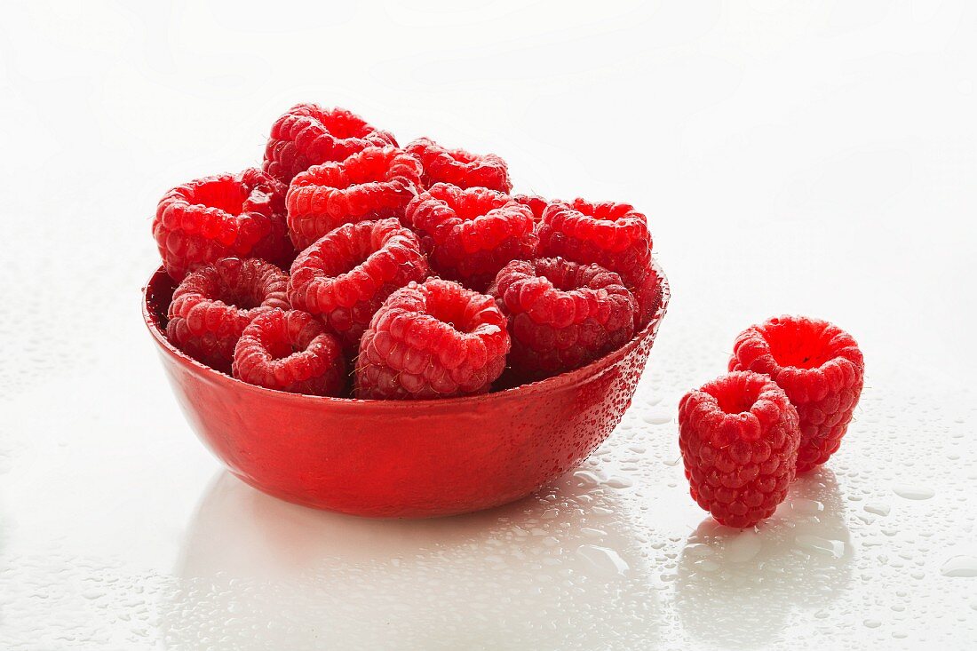 Bowl of Fresh Raspberries; Two Beside the Bowl