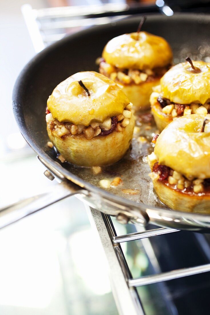 Bratapfel mit Rosinen und Nüssen in einer Pfanne