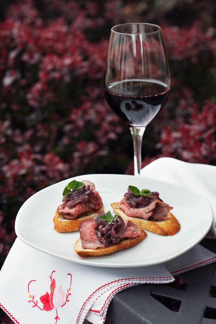 Roast beef canapes and a glass of red wine