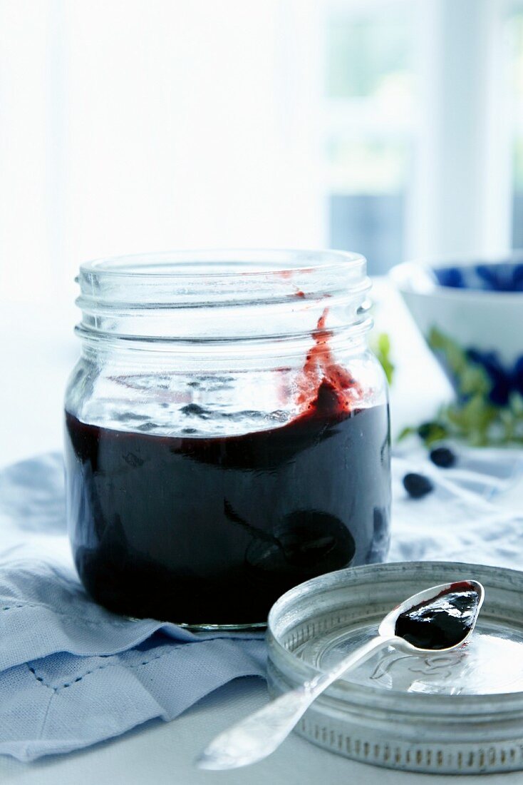 Blueberry jam in jar and on a spoon