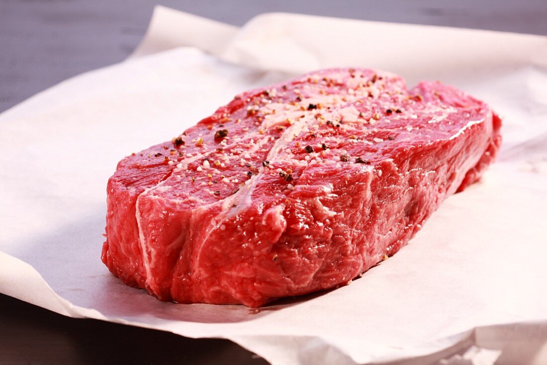 A raw, seasoned beef steak