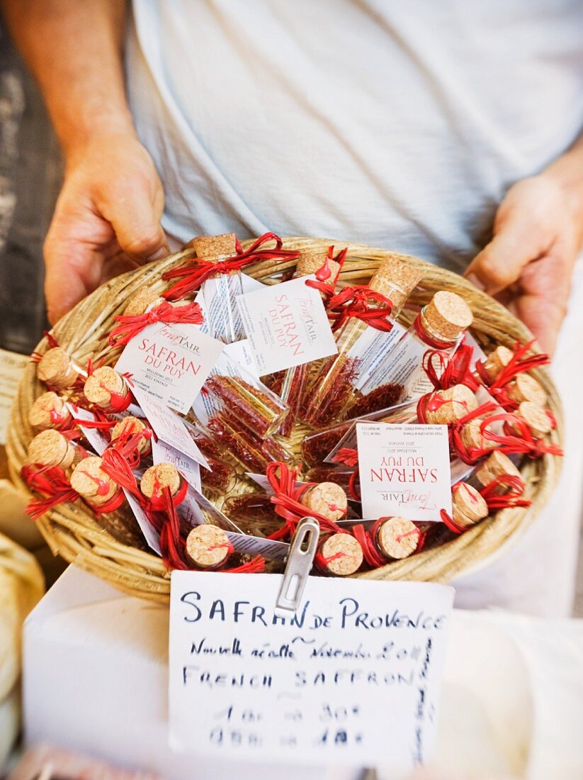 A man holding a basket with a jar of saffron