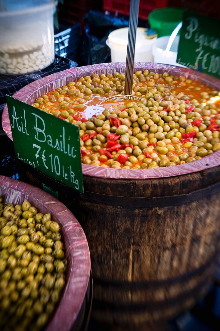 Preserved olives in wooden barrels at a market