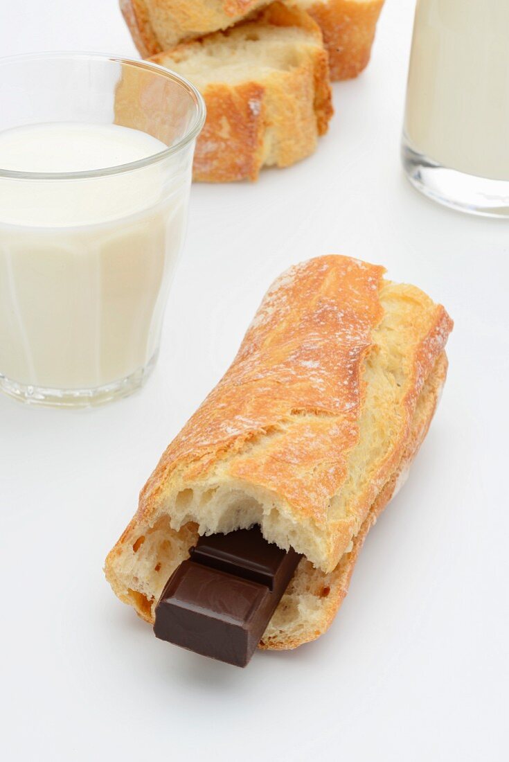 A baguette with chocolate and a glass of milk