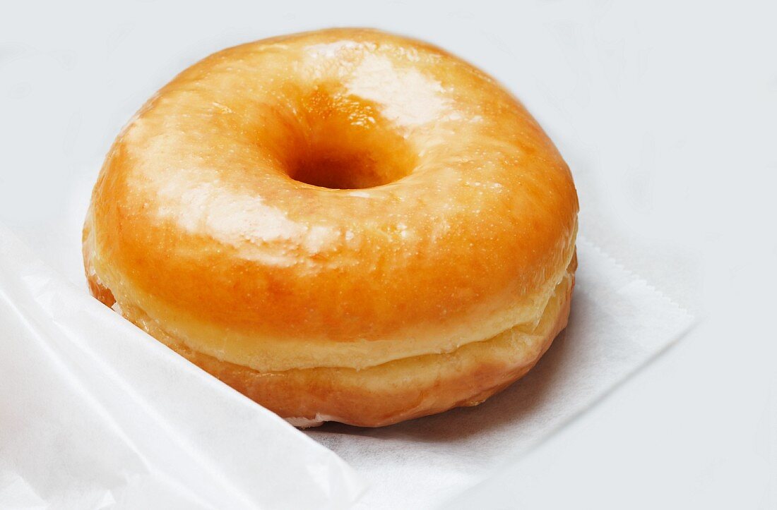 Glazed Doughnut on Parchment Paper in a Take-Out Box