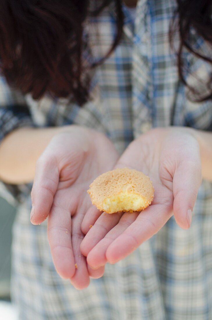 A girl holding a biscuit