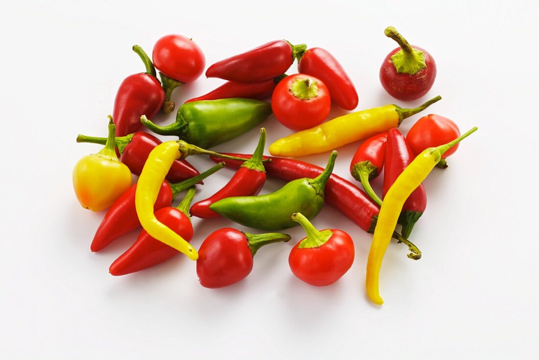 Various type of peppers on a white surface