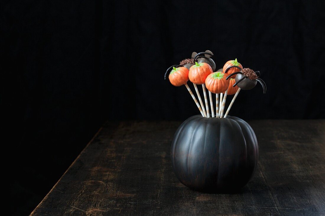 Cake Pops zu Halloween in einem schwarzen Kürbis