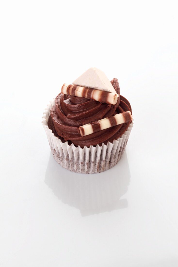 A chocolate cupcake decorated with chocolate sticks