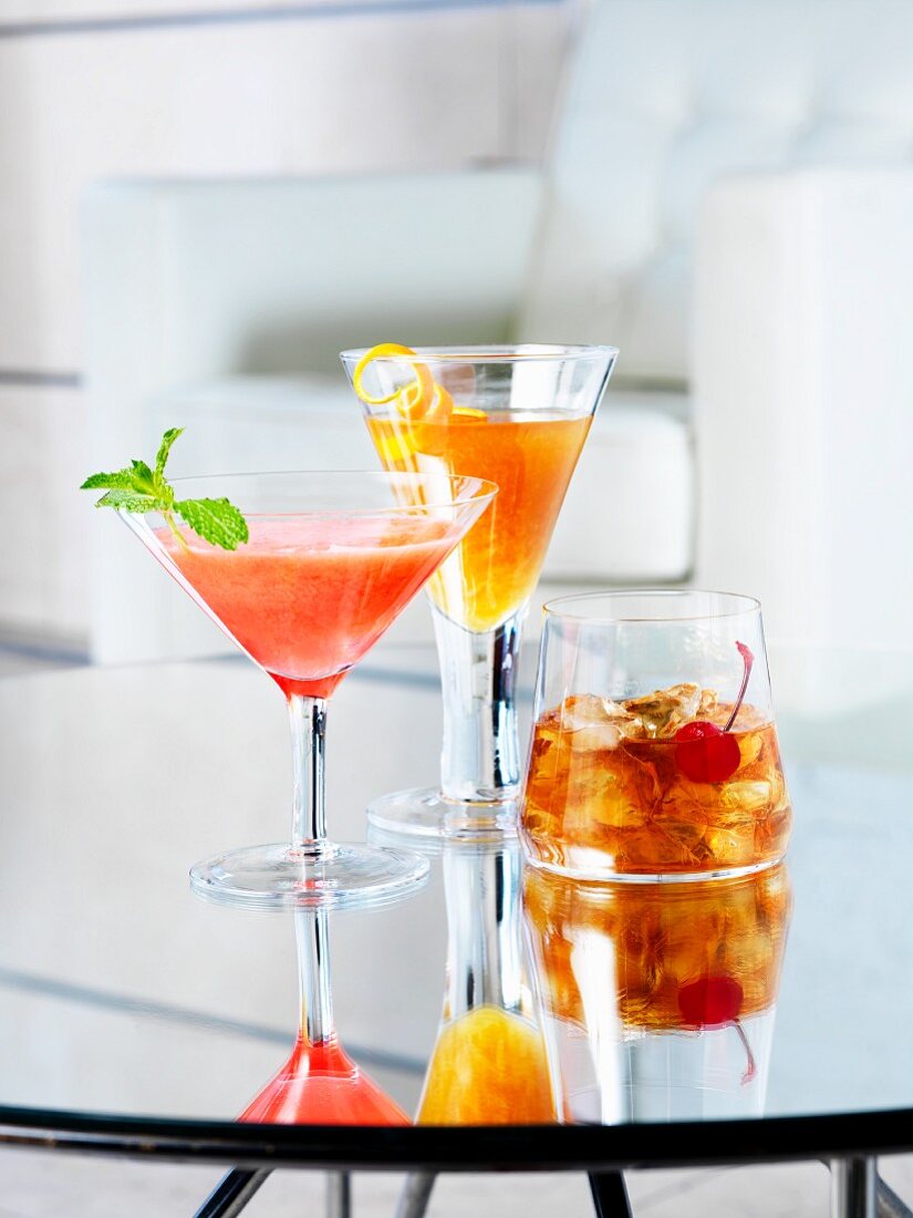 Verschiedene Cocktails auf Glastisch