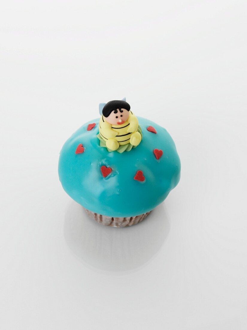 A turquoise cupcake decorated with a bee