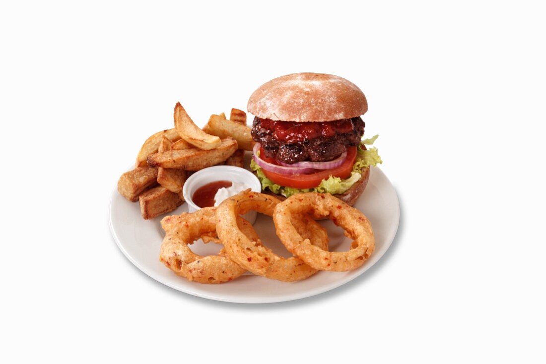 A hamburger with onion rings and chips