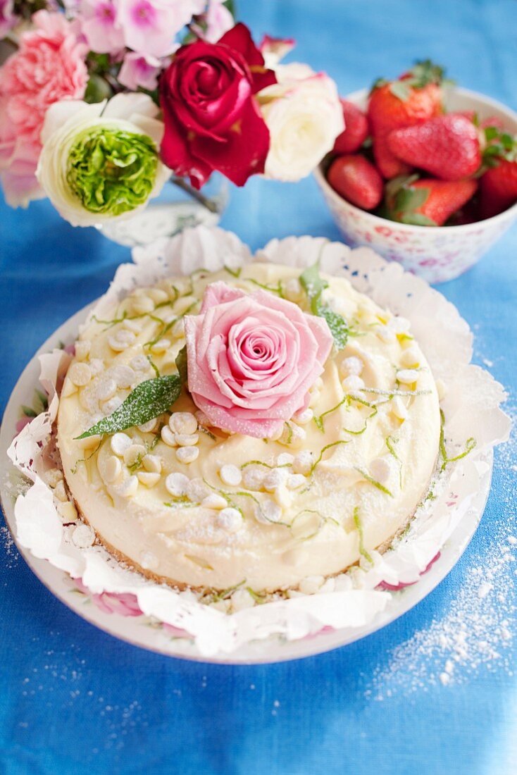 Käsesahnetorte mit weissen Chocolatechips, Limetten und Rosenblüte