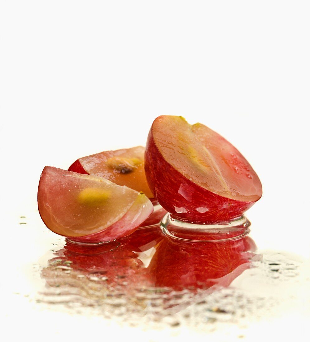 Sliced red grapes on a mirror