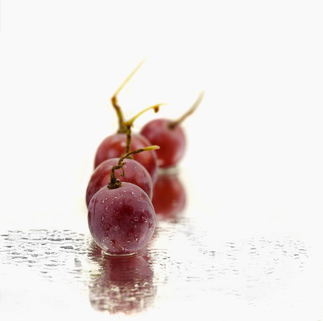 Red grapes on a mirror