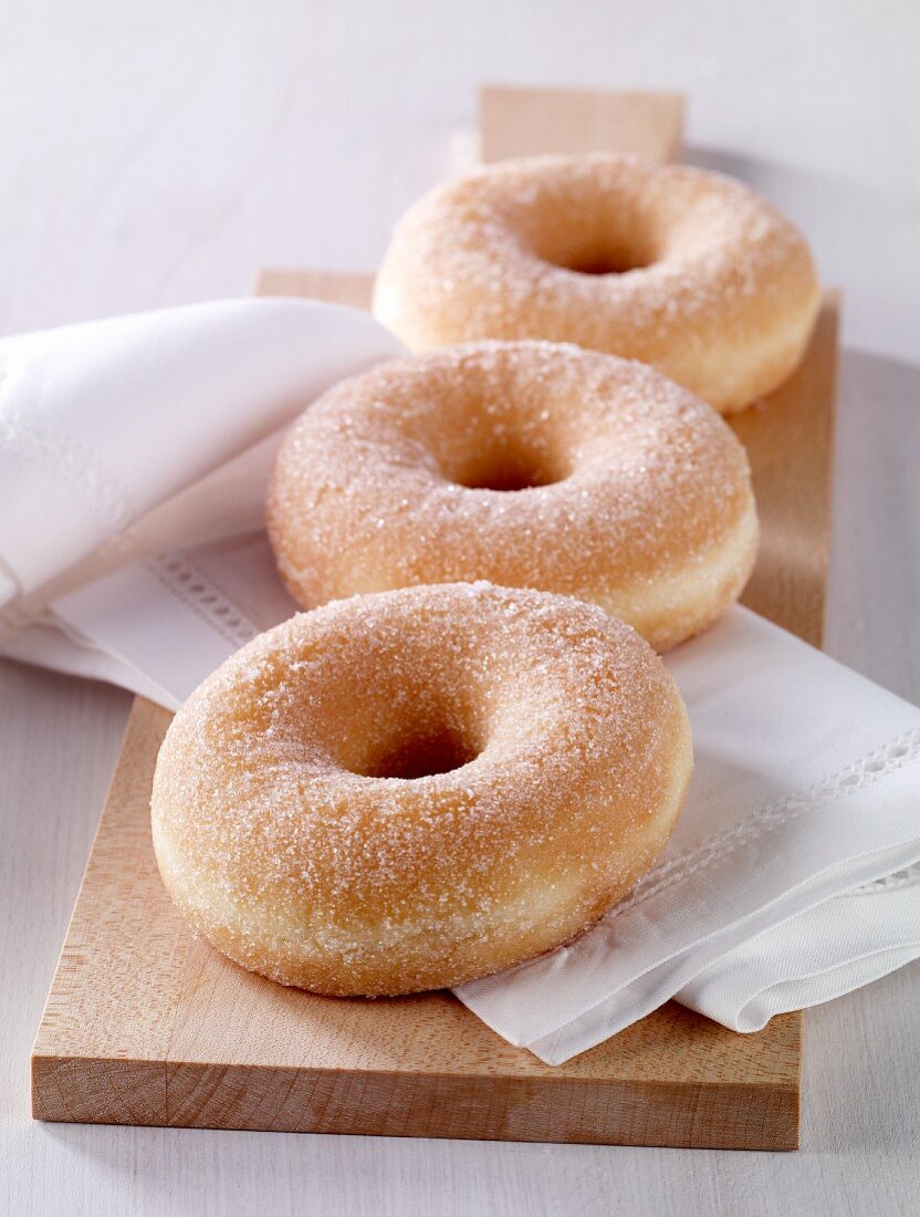 Sugared doughnuts on a chopping board