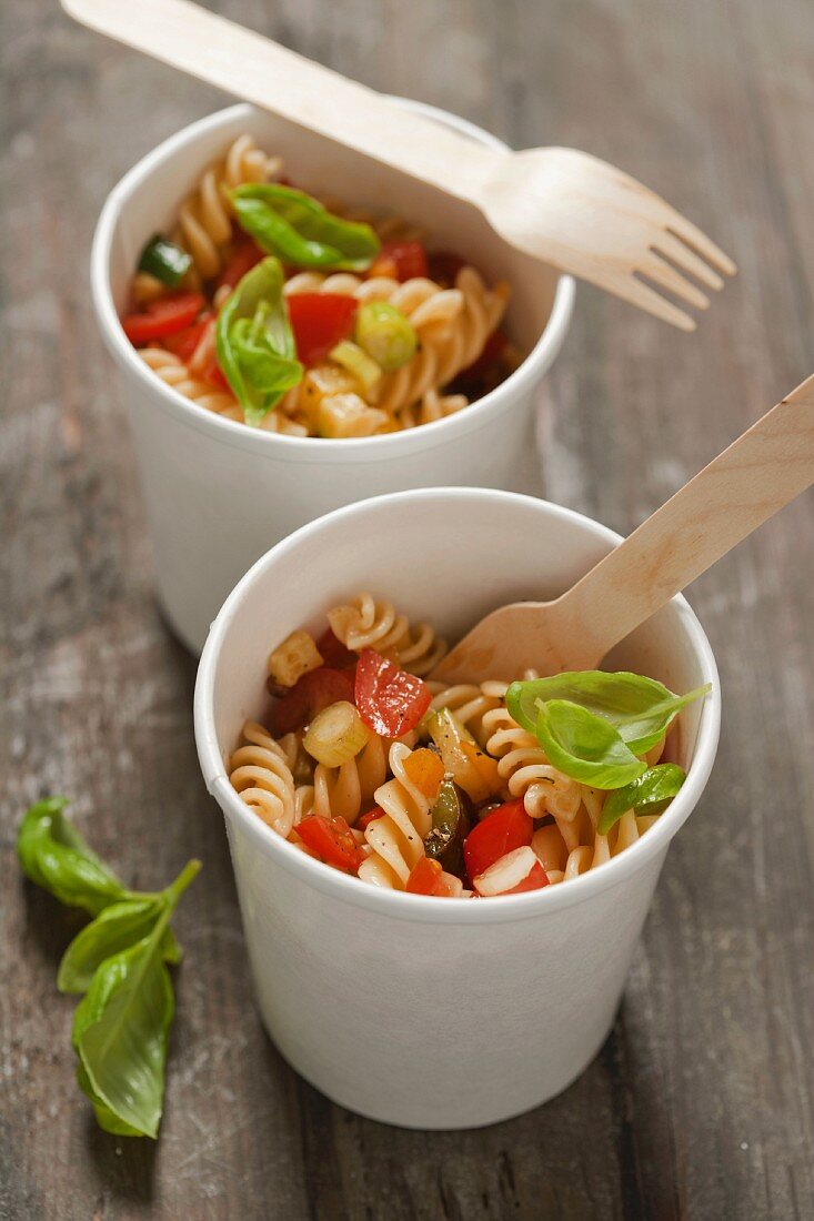 Fusilli with tomatoes, courgette and basil in paper cups