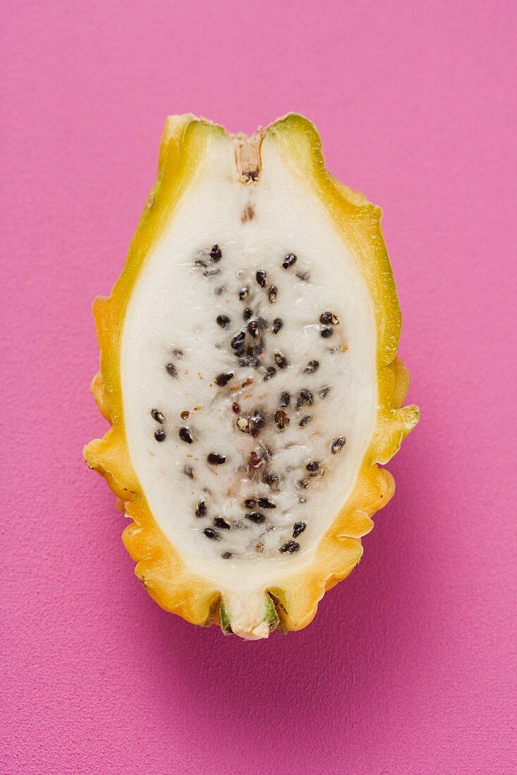 Half a pitahaya on a pink surface