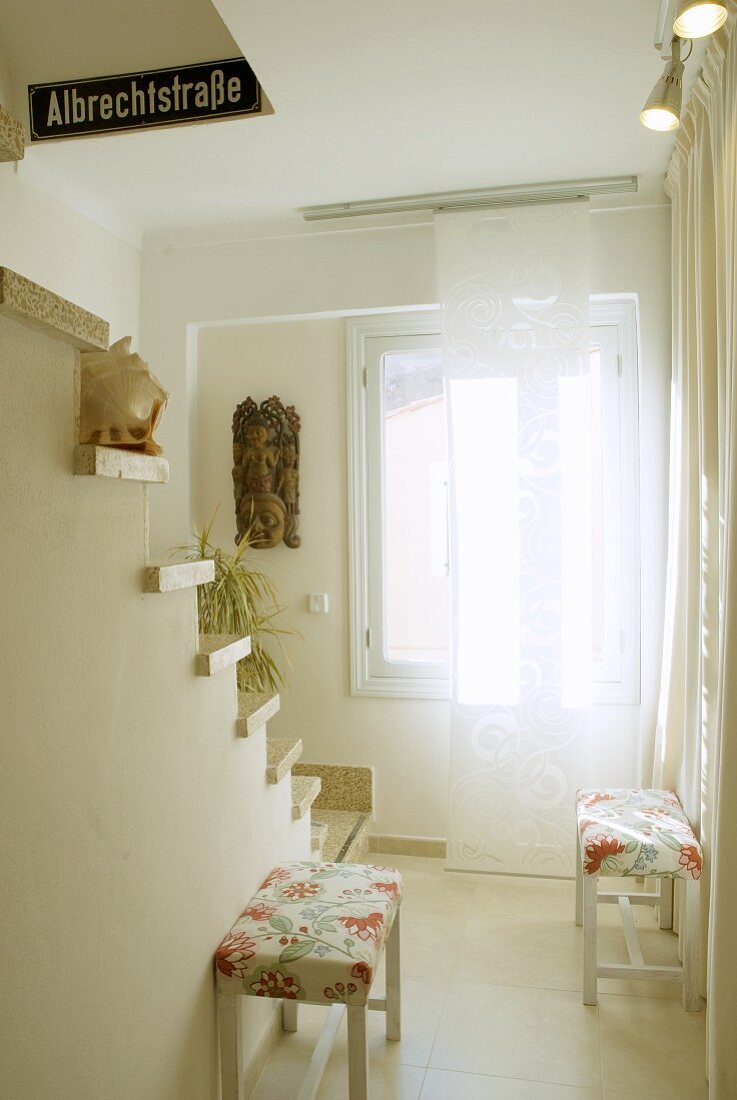 Bright stairwell with cantilever stair treads and stools with floral seat covers