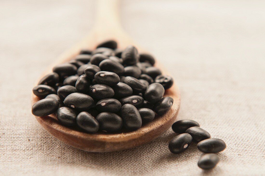 Black beans on a wooden spoon