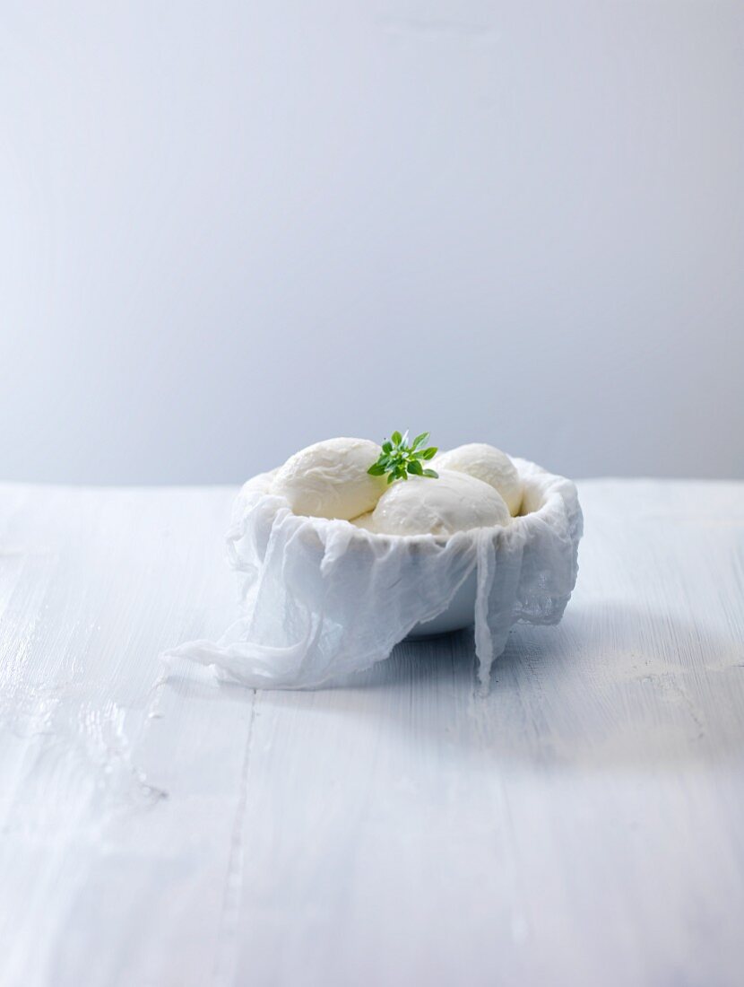 Mozzarella in bowl lined with a muslin cloth