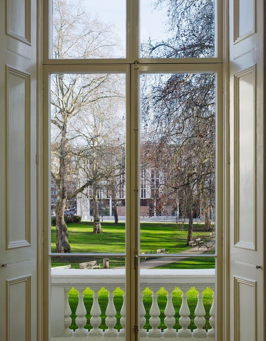 Blick durch Fenstertür mit Innenläden in den gepflegten Park des Goethe Instituts in London