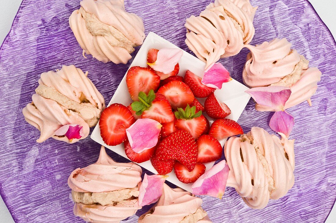 Meringues filled with chestnut cream and fresh strawberries on a purple plate