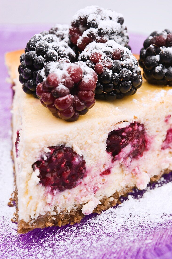 A slice of cheesecake with blackberries (close-up)