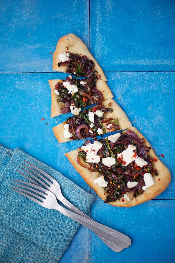 A slice of onion bread topped with feta cheese