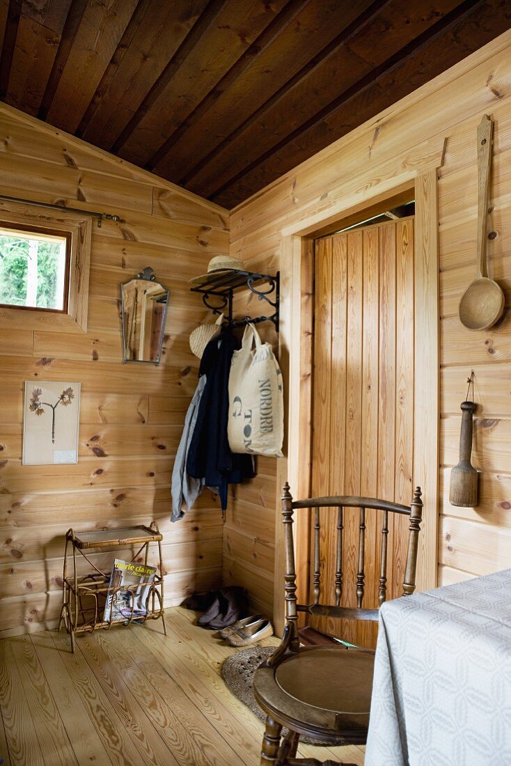 View from set dining table towards entrance area of simple wooden house