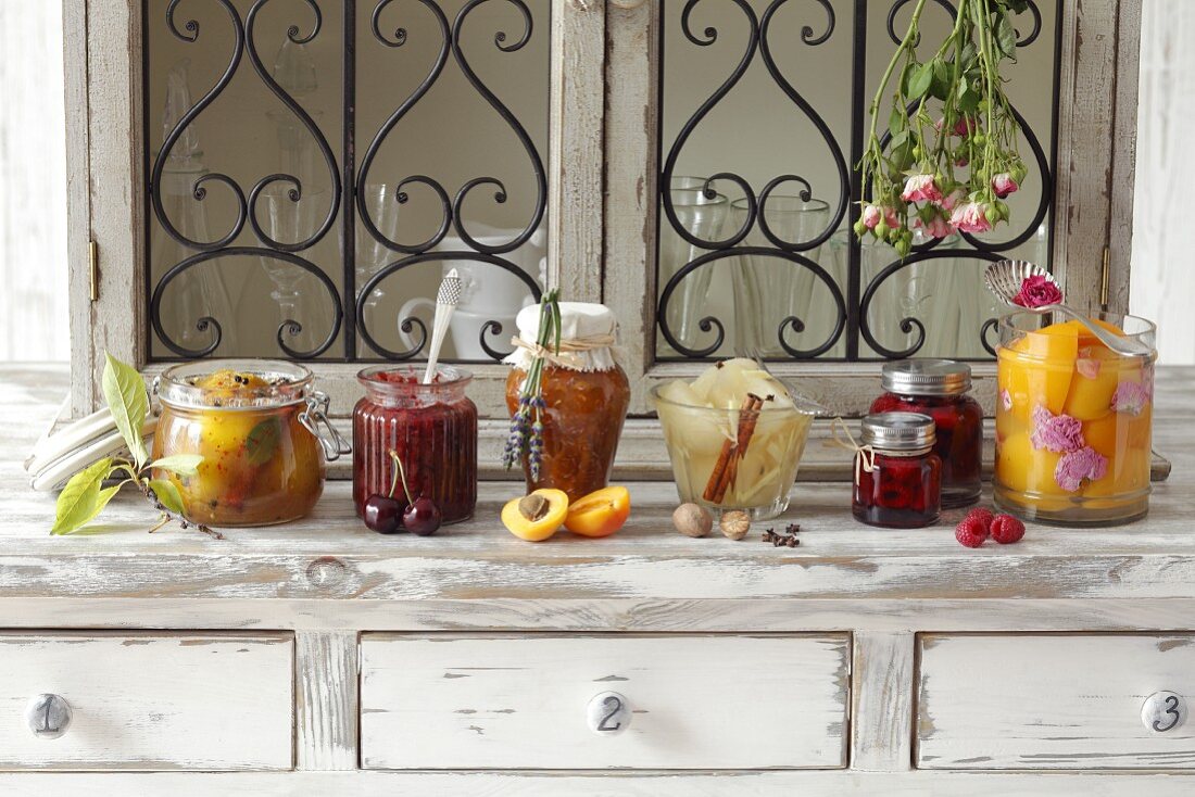Verschiedenes eingelegtes Obst, apricot jam with lavender, pears in vinegar, raspberries in sugar syrup, peaches with dried roses