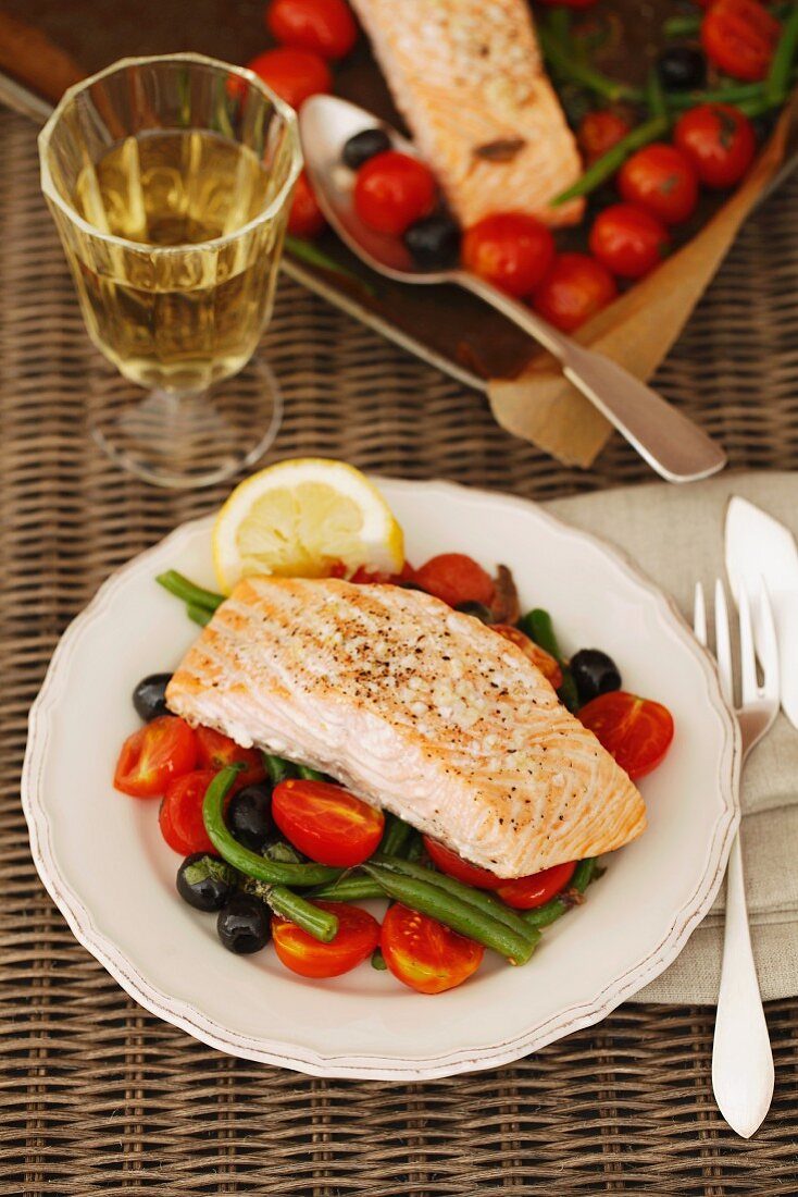 Salmon fillet on a tomato and bean salad with olives