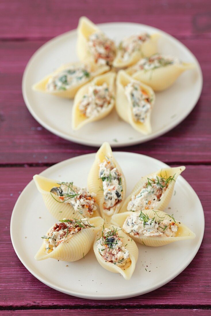 Conchiglie pasta filled with quark, dried tomatoes and olives with dill