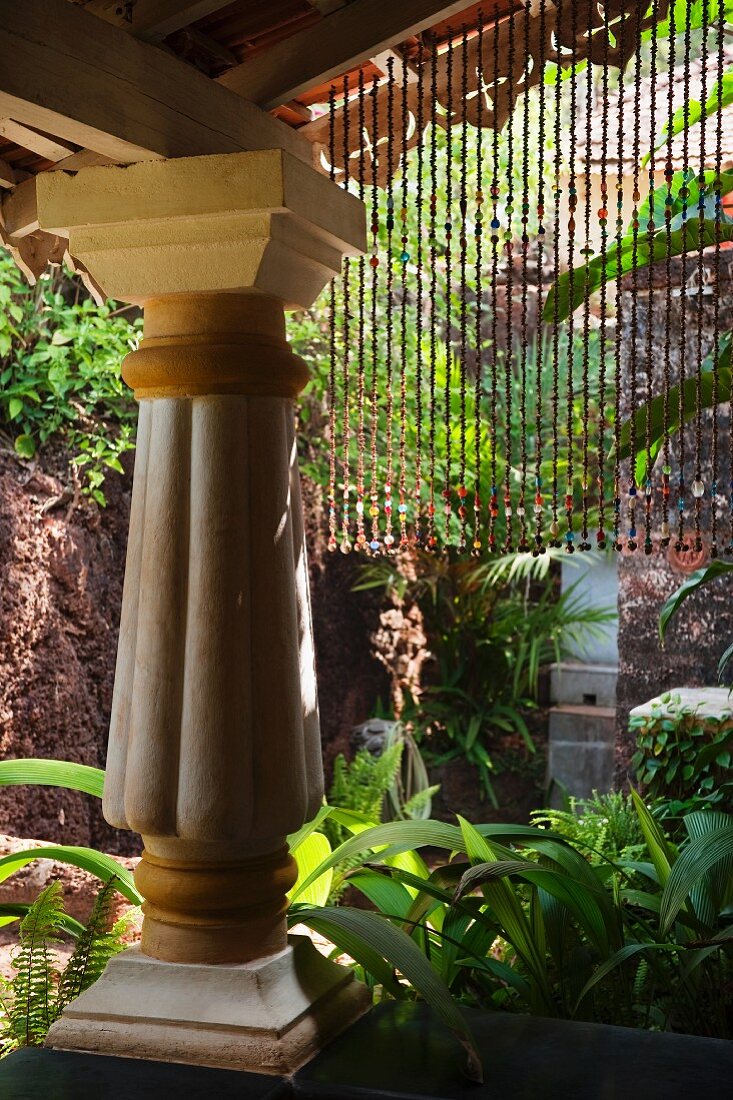 Colonial-style porch supported on massive column in tropical garden