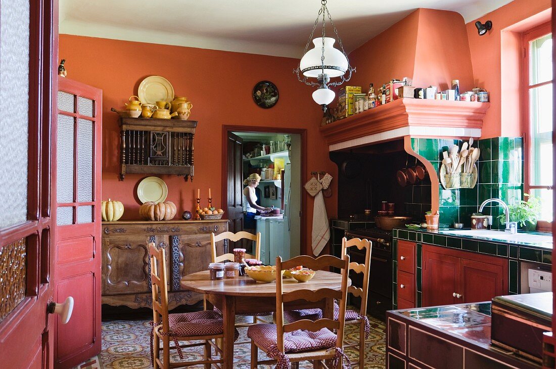 Red Provencal kitchen with orignial 19C floor tiles and traditional Provencal furniture