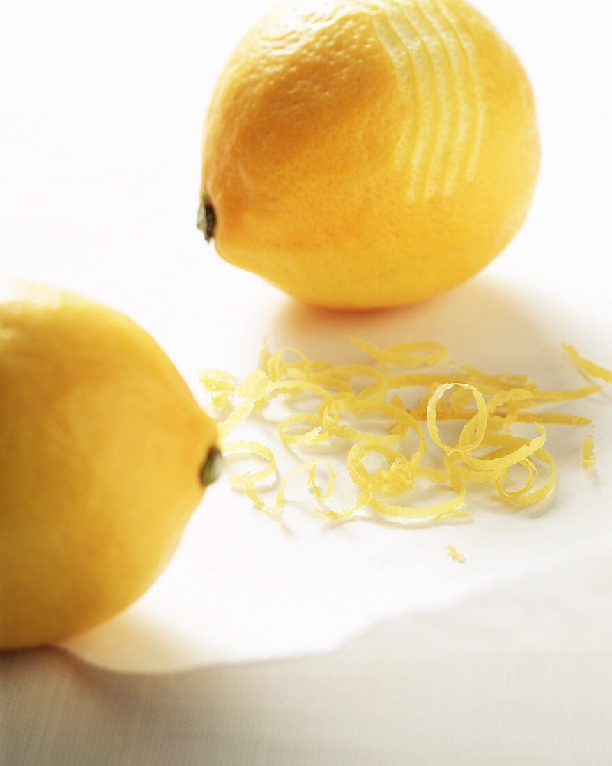 Zwei Zitronen mit Zitronenzesten