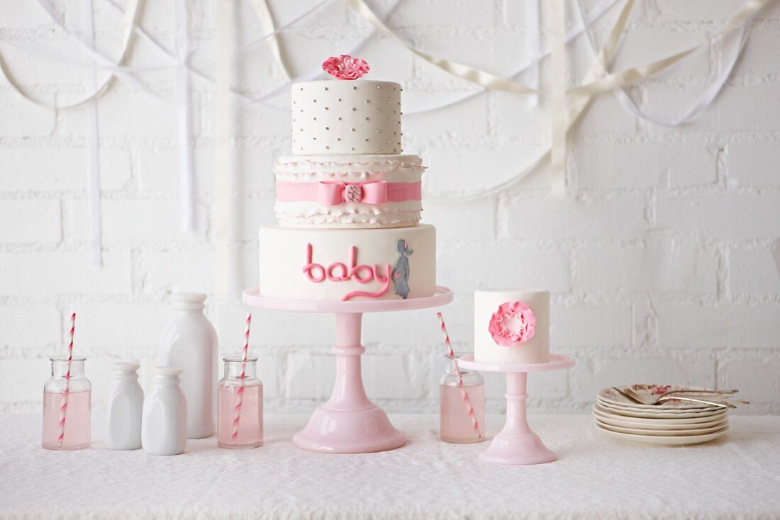 Dreistöckige weiße Torte mit rosa Zuckerschrift baby