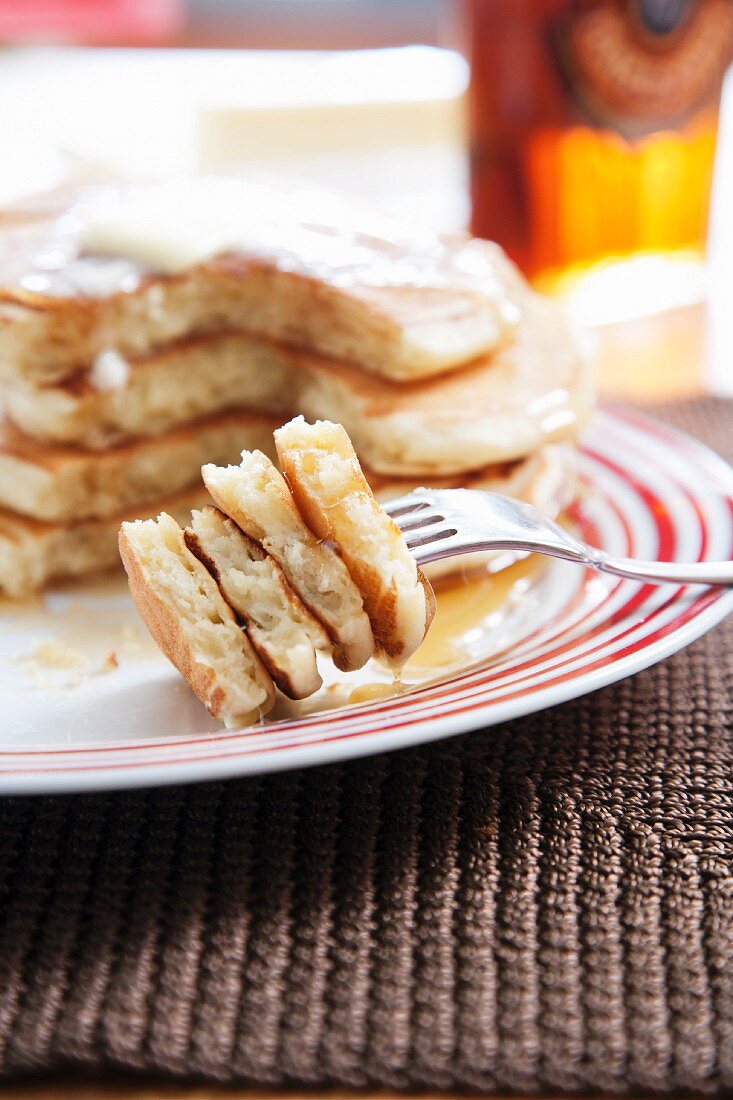 Stack of Buttermilk Pancakes; Bite Pierced on a Fork