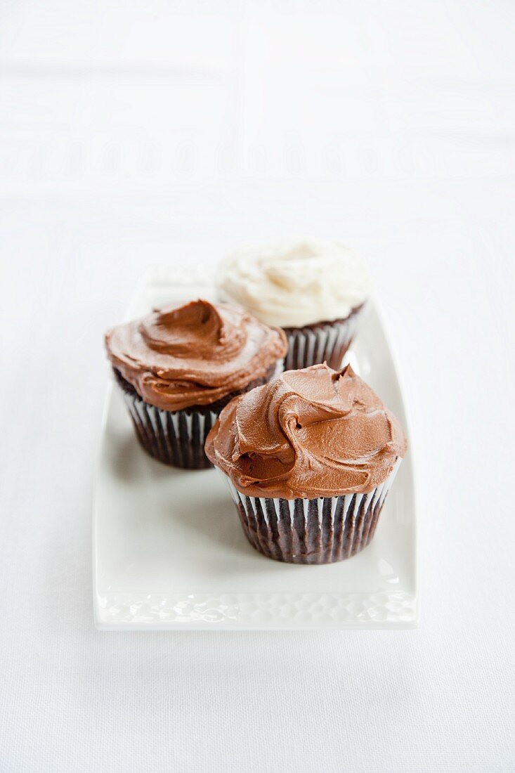 Three Chocolate Cupcakes; Two with Chocolate Frosting, One with Vanilla Frosting