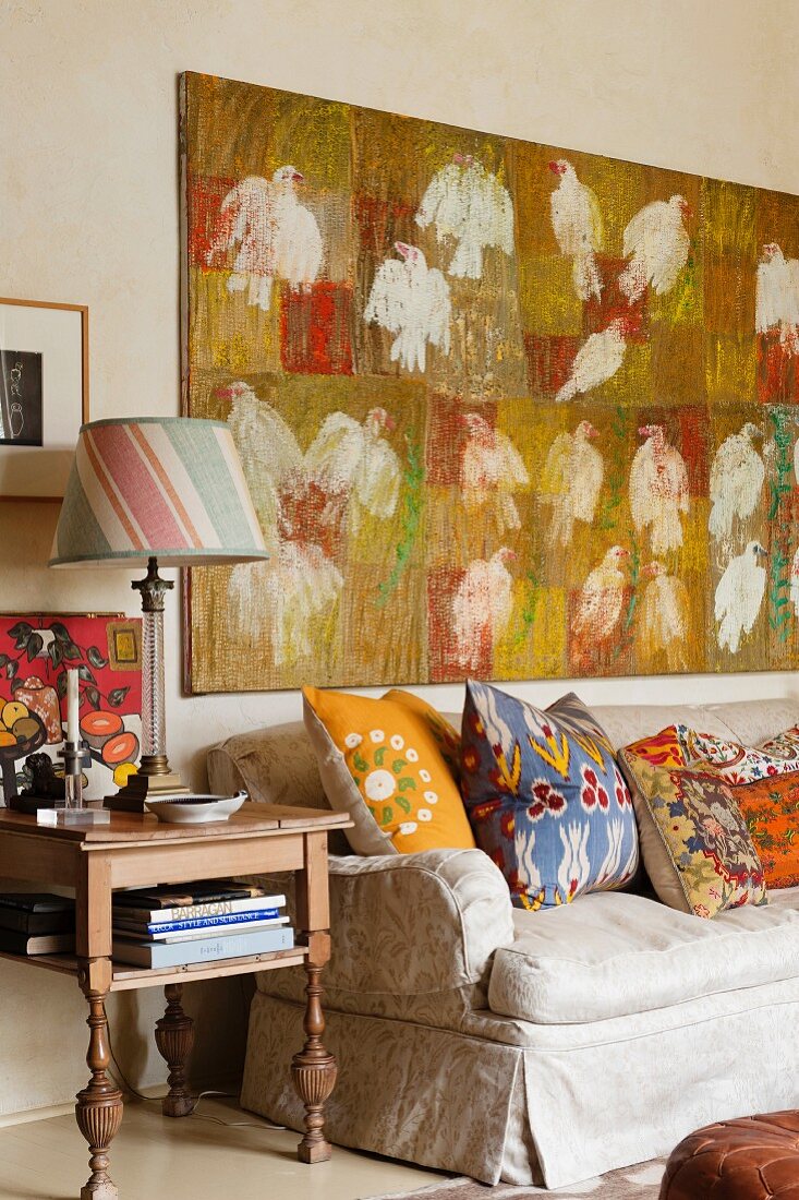 Assorted Kathryn Ireland design cushions on sofa beneath bird artwork