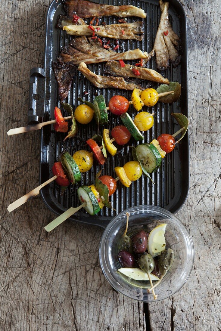 Marinated vegetables kebabs and mushrooms on a barbecue