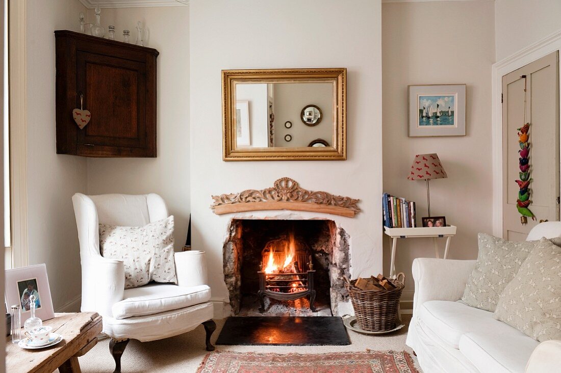 Traditional English living room with pale sofa set in front of open fireplace