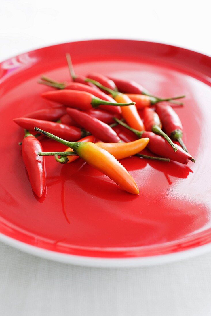 Fresh chilli peppers on a red plate