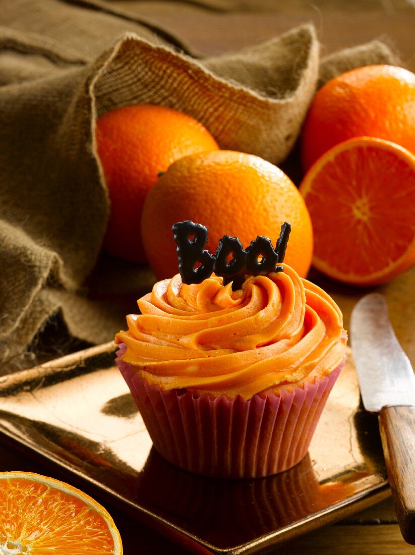 Orangen-Cupcake und frische Orangen