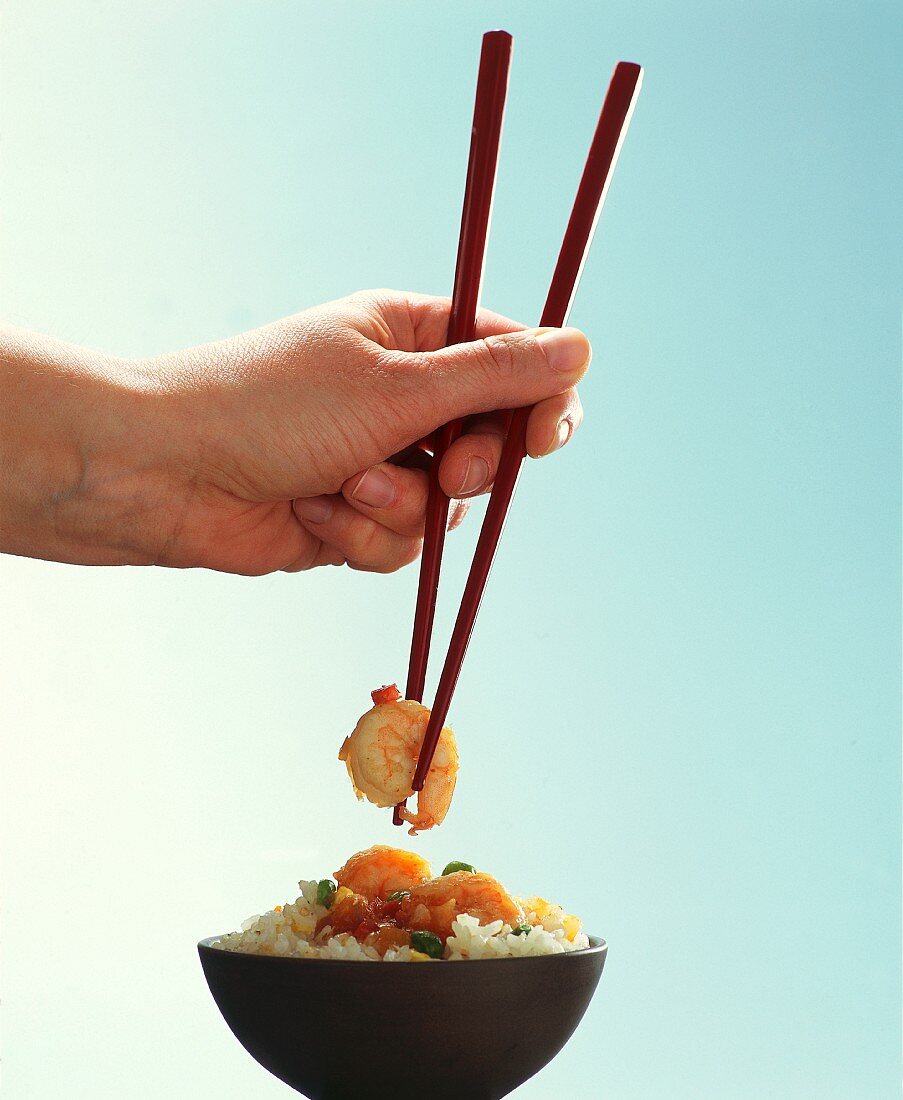 A hand holding chopsticks