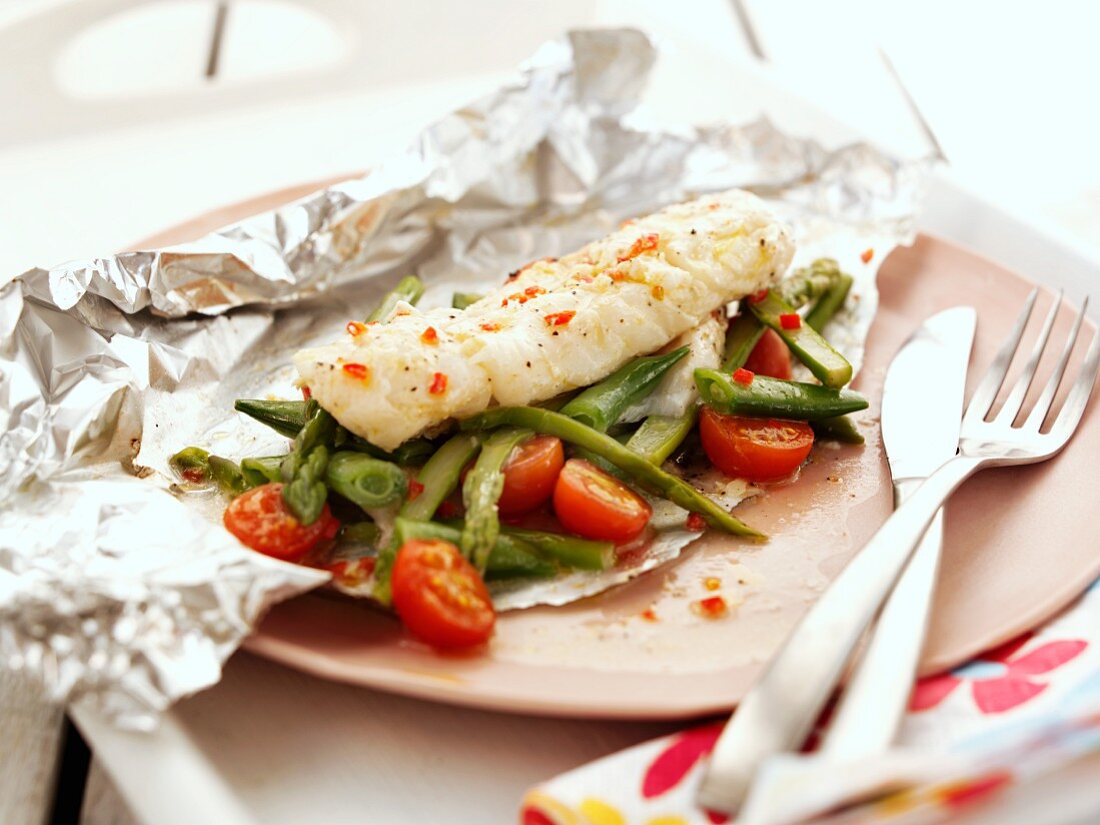 Cod with asparagus and tomatoes in foil