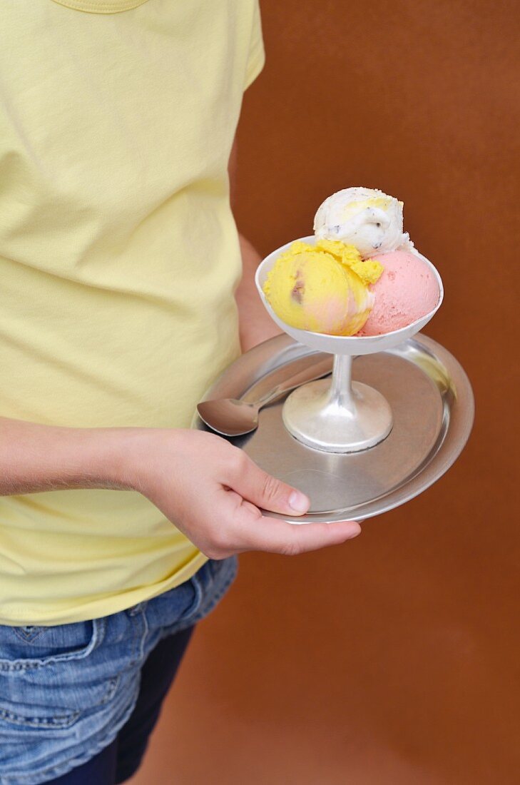 A girl holding a mixed ice cream sundae