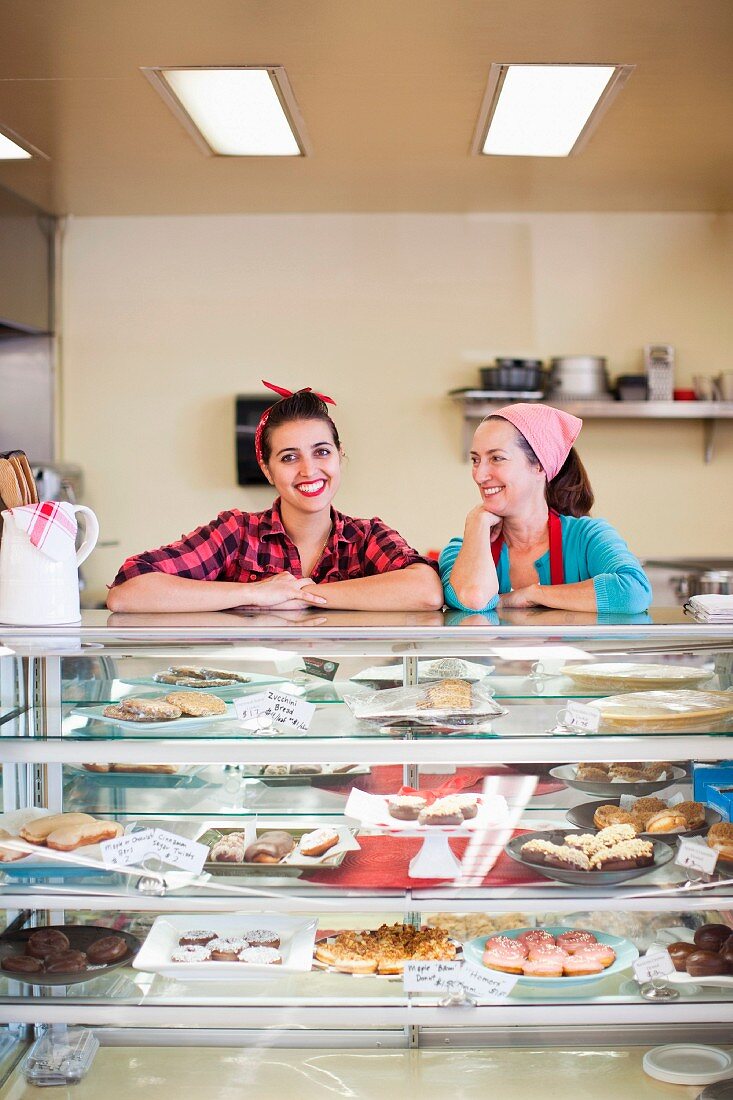 Two women standing at counter of bakery