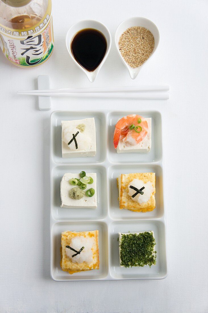 Tofu topped with grated radish, sliced spring onions, a prawn and seaweed